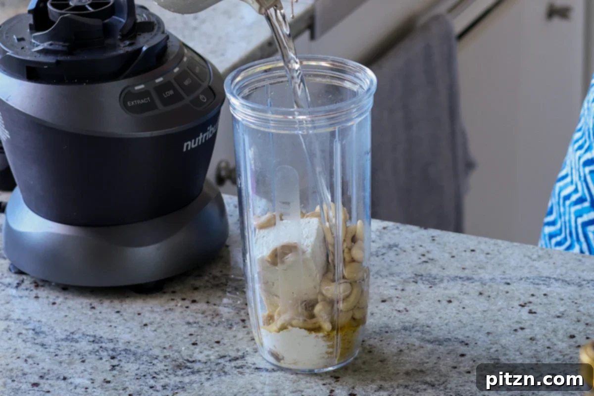 All cream sauce ingredients, including cashews, tofu, and nutritional yeast, ready to be blended for a smooth sauce.