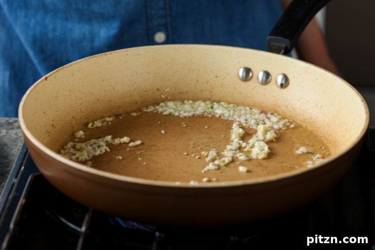 Golden Paprika Tofu with Creamy Garlic Parmesan Orzo 14 Adding minced garlic to the skillet, beginning the aromatic sauce base.