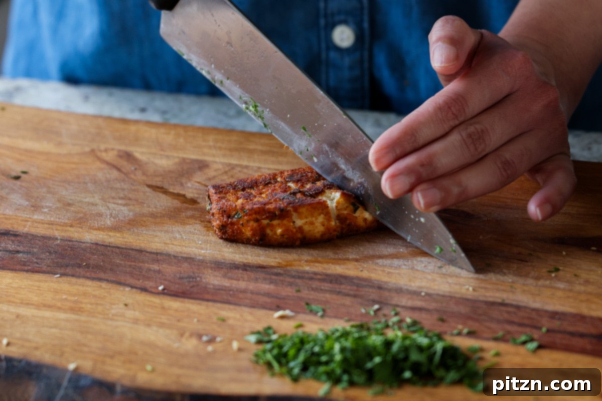 Golden Paprika Tofu with Creamy Garlic Parmesan Orzo 26 Crispy paprika tofu being carefully sliced on a cutting board.