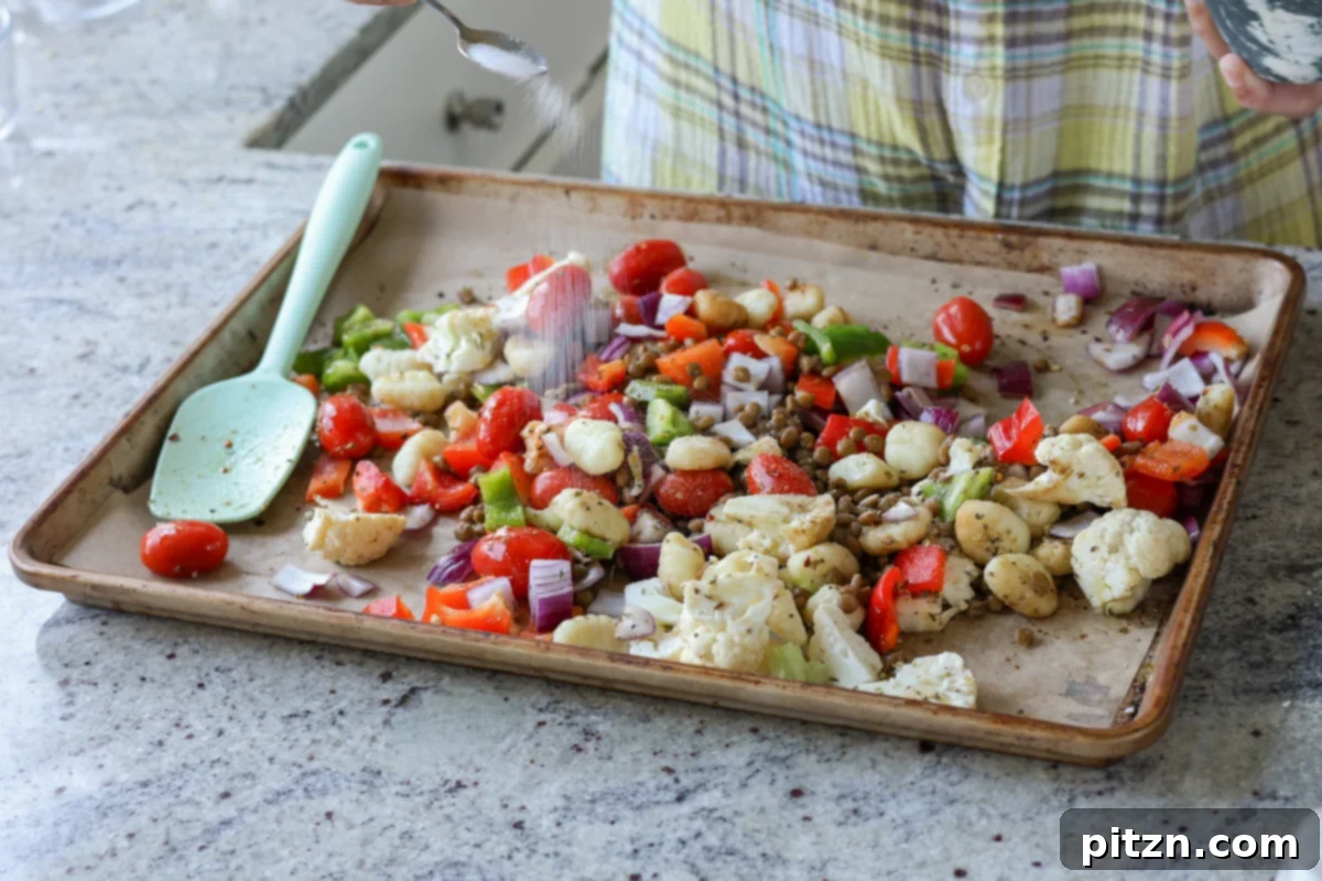 One-Pan Mediterranean Gnocchi: No Boil, Big Flavor 10 Gnocchi and vegetables seasoned with salt and spices, ready for a final toss on the baking sheet.