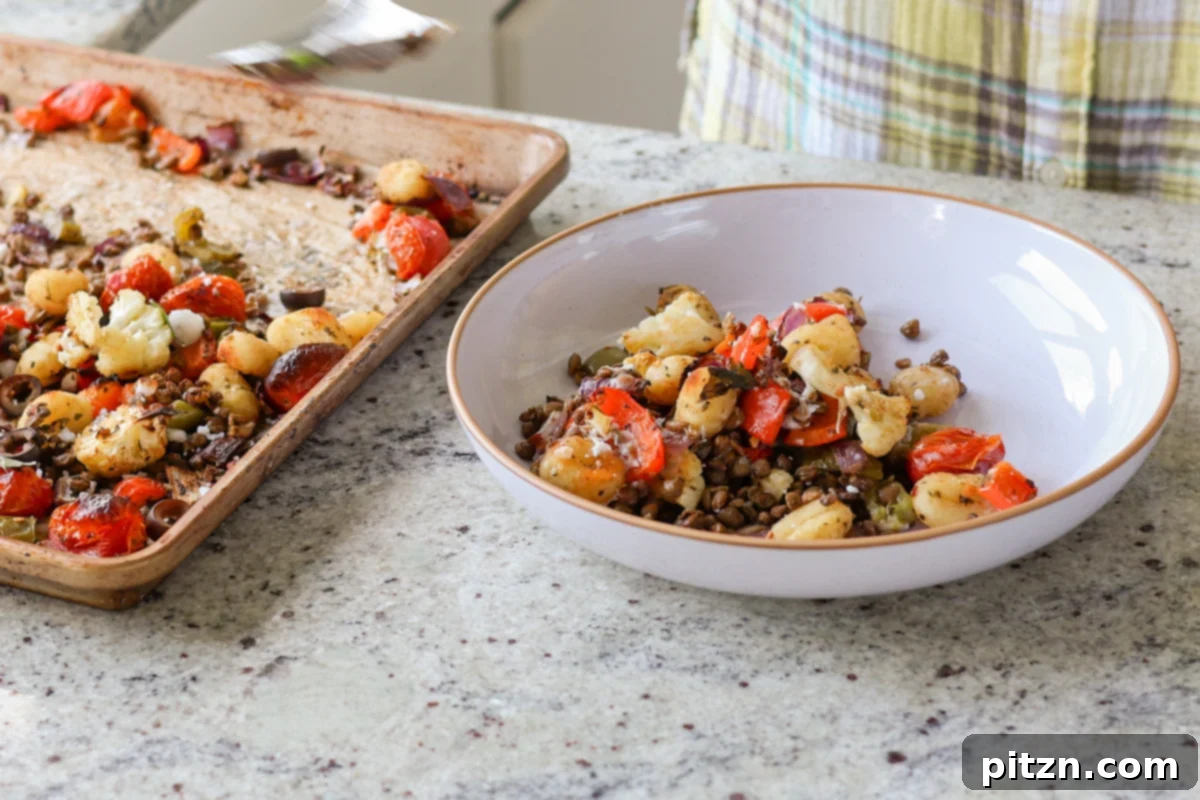 One-Pan Mediterranean Gnocchi: No Boil, Big Flavor 14 A person serving a portion of Mediterranean sheet pan gnocchi into a bowl.