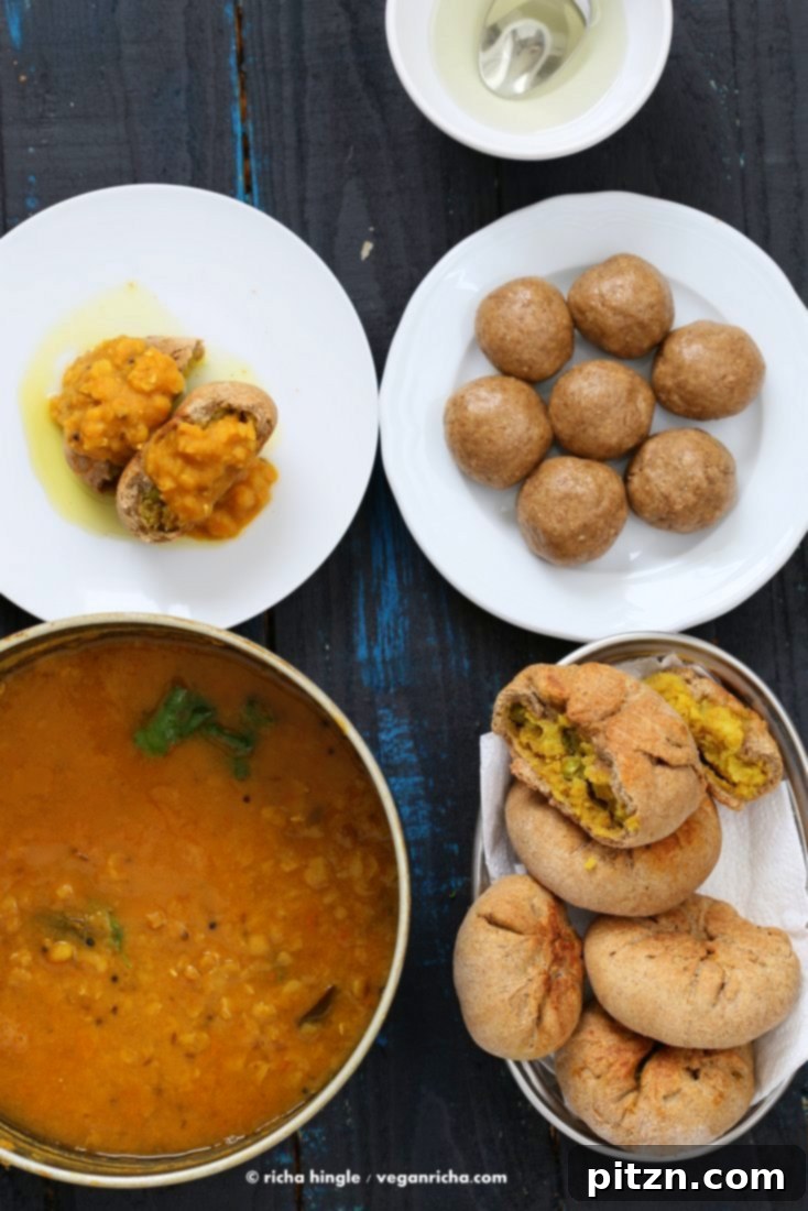 Dal Baati pastries served alongside Gond Atte ke Ladoo, a traditional Indian dessert.