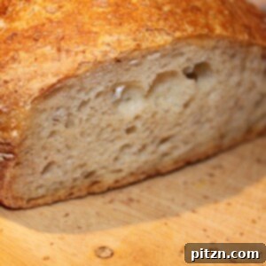 No knead bread sliced in half on a wooden work surface
