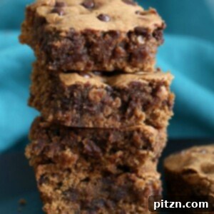 Chewy Vegan Almond Butter Blondies studded with chocolate chips, presented as squares on a serving plate. Gluten-free option.