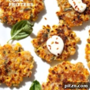 Crispy Basil Jalapeno Corn Fritters arranged on a plate with fresh basil leaves. Easy, gluten-free, soy-free vegan recipe.