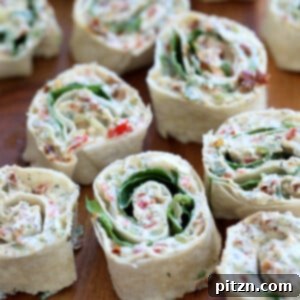 Colorful Tortilla Roll Ups with a creamy tofu herb cream cheese filling and sun-dried tomatoes, arranged on a serving platter. Vegan, nut-free, can be gluten-free.