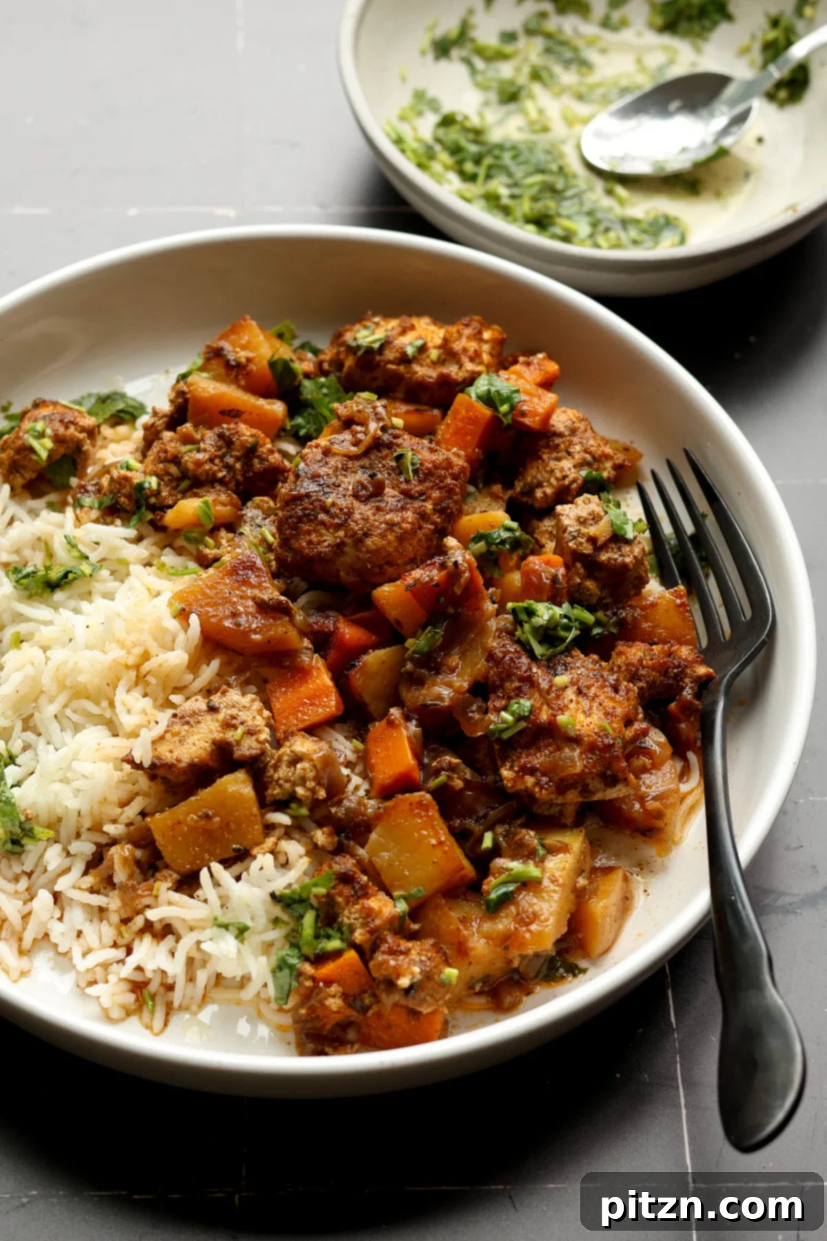 One Pan Chicken Style Braised Tofu and Vegetables 4 Braised tofu and vegetables served in a bowl alongside fluffy rice and drizzled with fresh herb sauce, highlighting its vibrant presentation.