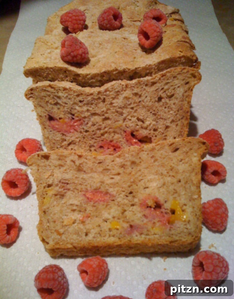 Wholesome Mango Raspberry Wheat Loaf 3 Close-up of the freshly baked Mango and Raspberry Wheat Bread, highlighting its rustic texture and delightful fruit distribution.