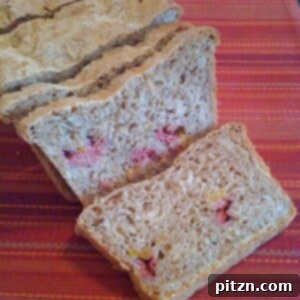 Wholesome Mango Raspberry Wheat Loaf 4 A beautifully crafted loaf of Mango and Raspberry Wheat Bread, ready to be sliced and enjoyed.