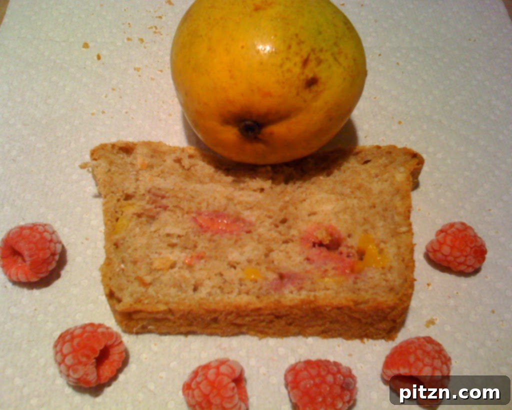 Wholesome Mango Raspberry Wheat Loaf 5 A freshly baked loaf of Mango and Raspberry Wheat Bread, presented invitingly on a wooden board.