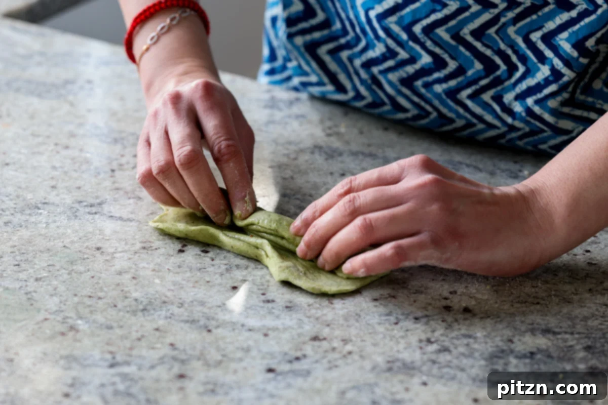 Yeast-Free Spinach Paratha Flatbread 24 The process of folding the dough accordion-style, a technique to achieve a flaky texture.