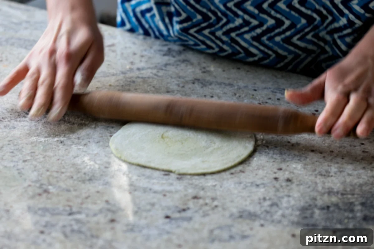 Yeast-Free Spinach Paratha Flatbread 25 Rolling out the dough for a second time after folding, enhancing the flaky texture.