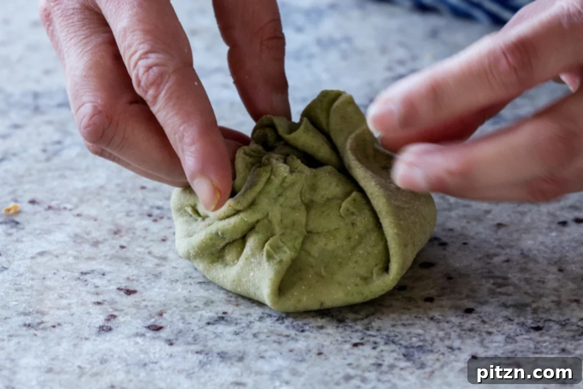 Yeast-Free Spinach Paratha Flatbread 29 Carefully folding the spinach dough edges over the filling, creating a sealed dumpling shape.