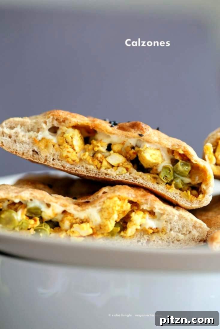 Delicious Vegan Naan Calzone filled with spicy tofu scramble and melted vegan cheese, perfect for a plant-based meal.