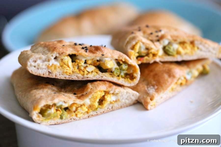 Freshly baked vegan naan calzones brushed with melted vegan butter, sliced, and ready to be served.