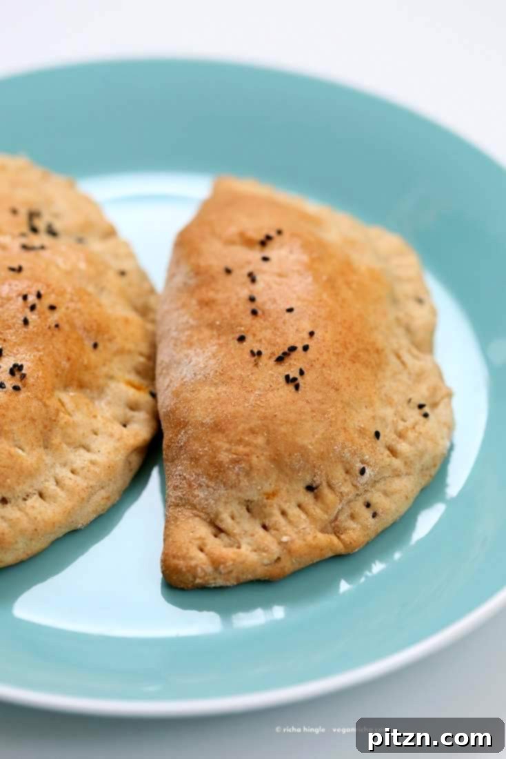 A close-up shot of a baked Vegan Naan Calzone, showing its golden crust and delicious filling inside.