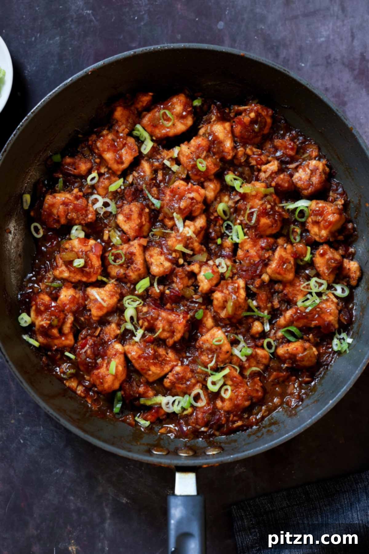 Indochinese Garlic Black Pepper Chicken 2 Indo-Chinese garlic pepper tofu simmering in a pan with fresh green onions