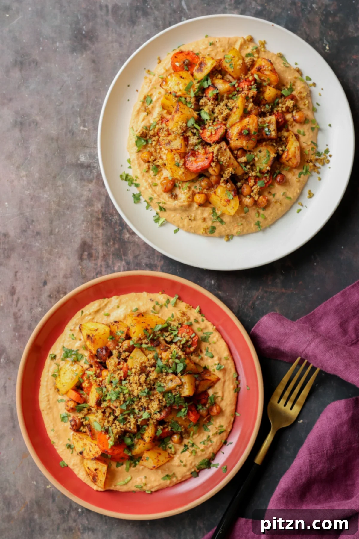 Plates of harissa bean puree topped with roasted vegetables and baharat walnuts