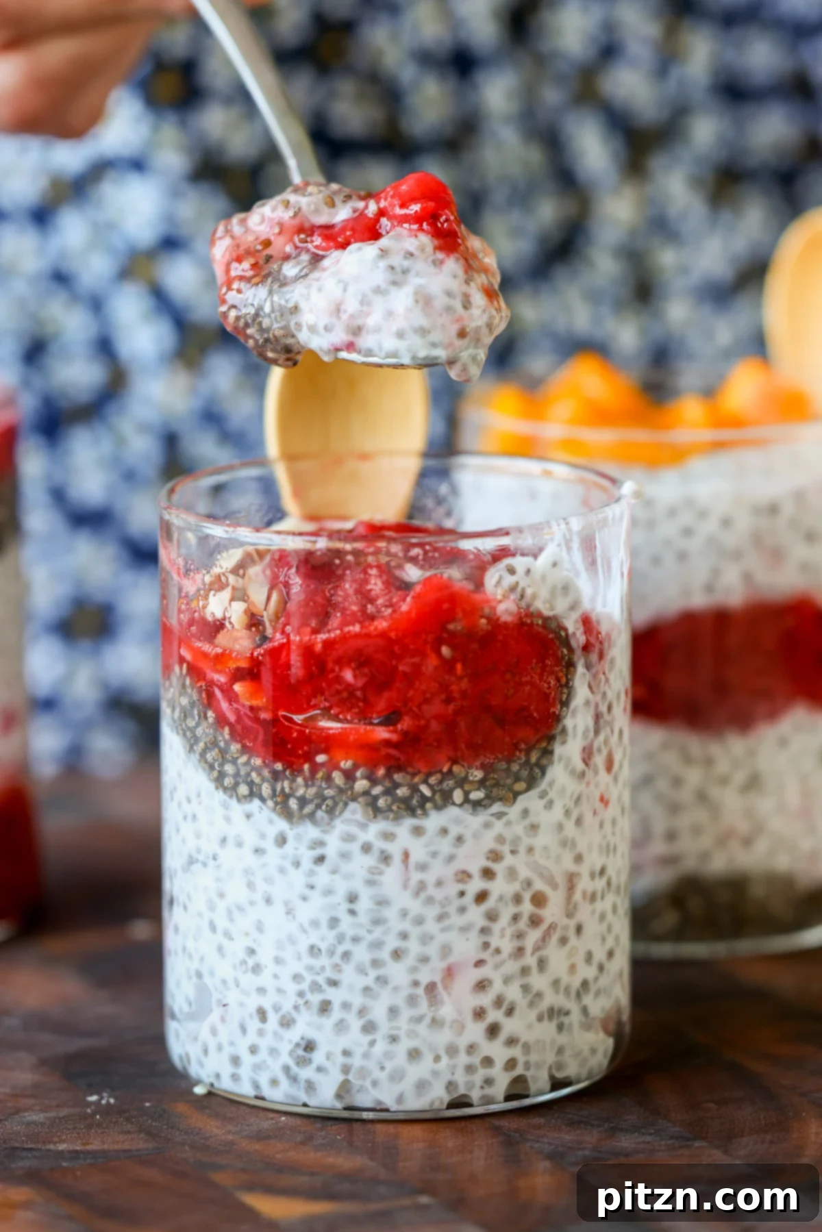 A spoonful of strawberry chia pudding being lifted from a glass.
