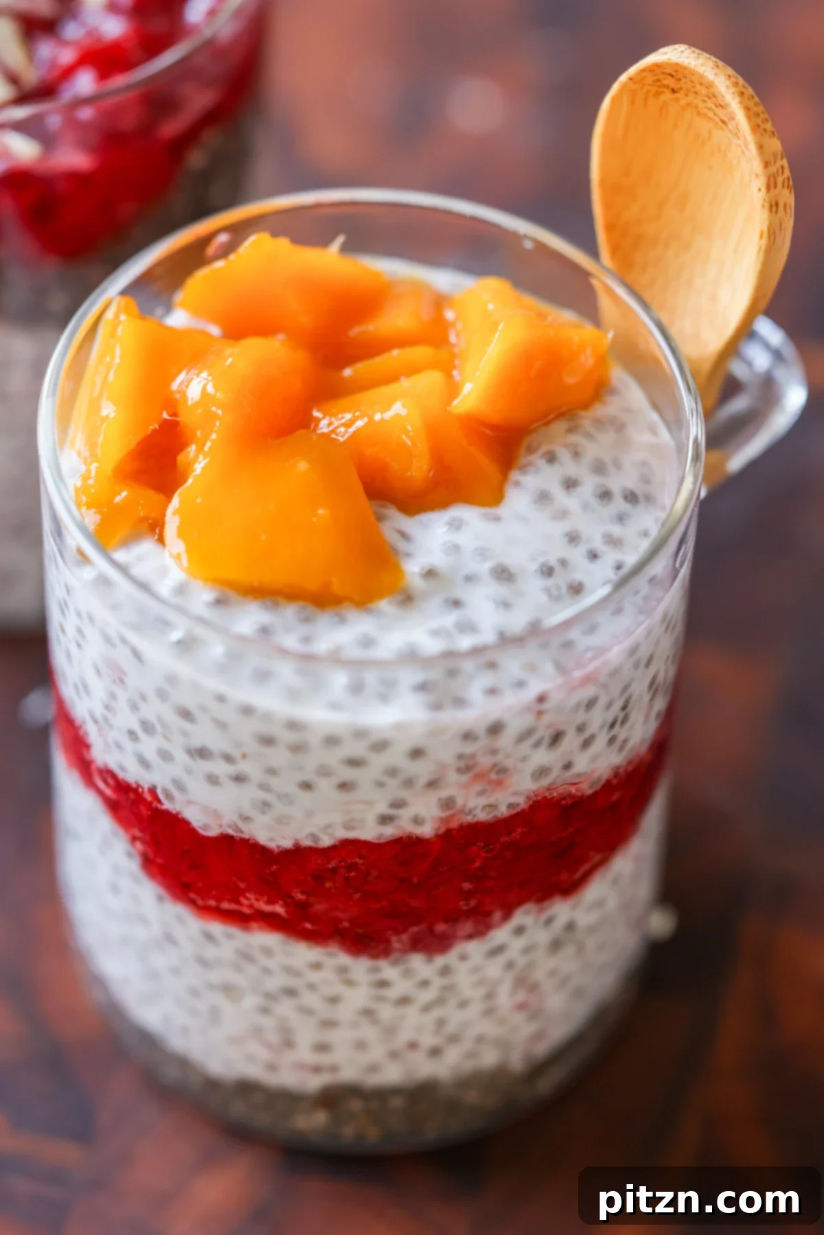 Strawberry chia pudding topped with fresh mango chunks.