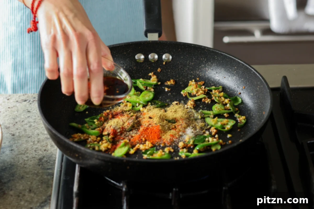 adding ground spices and sauces to the pan
