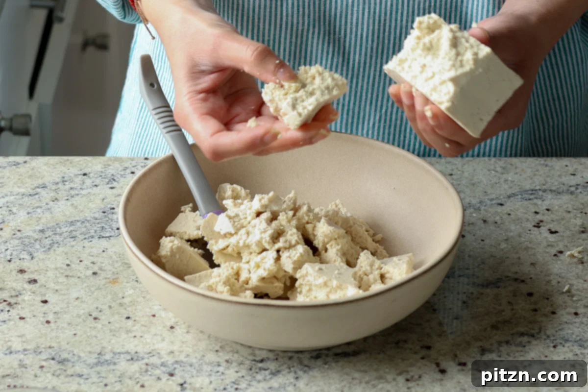 breaking the tofu into pieces