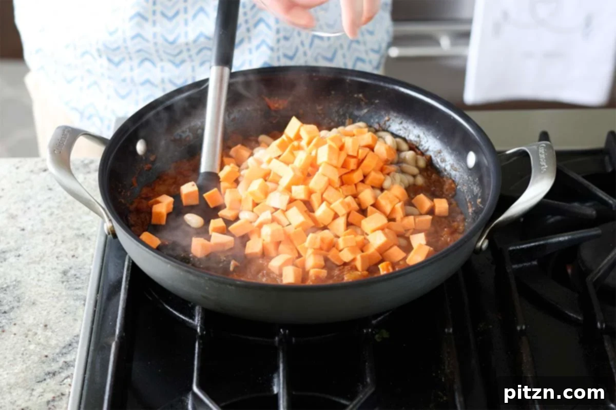 Aromatic Sweet Potato and White Bean Curry Stew 16 adding sweet potatoes to the pan