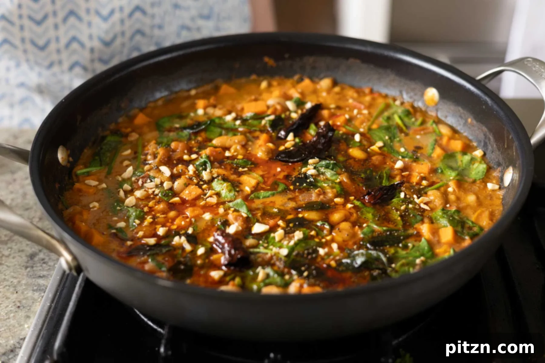 Aromatic Sweet Potato and White Bean Curry Stew 25 Indian-inspired white bean stew in the pan with peanuts on top