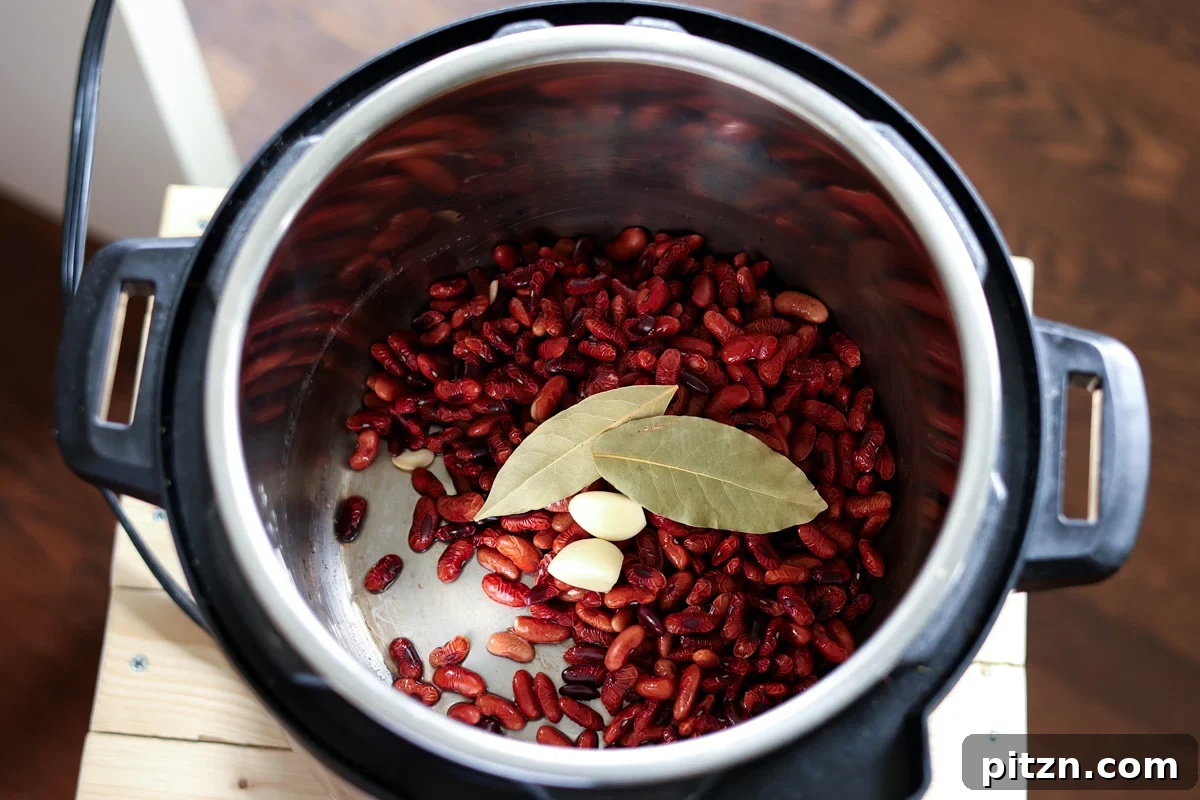 adding kidney. beans, garlic, and bay leaves to the Instant Pot