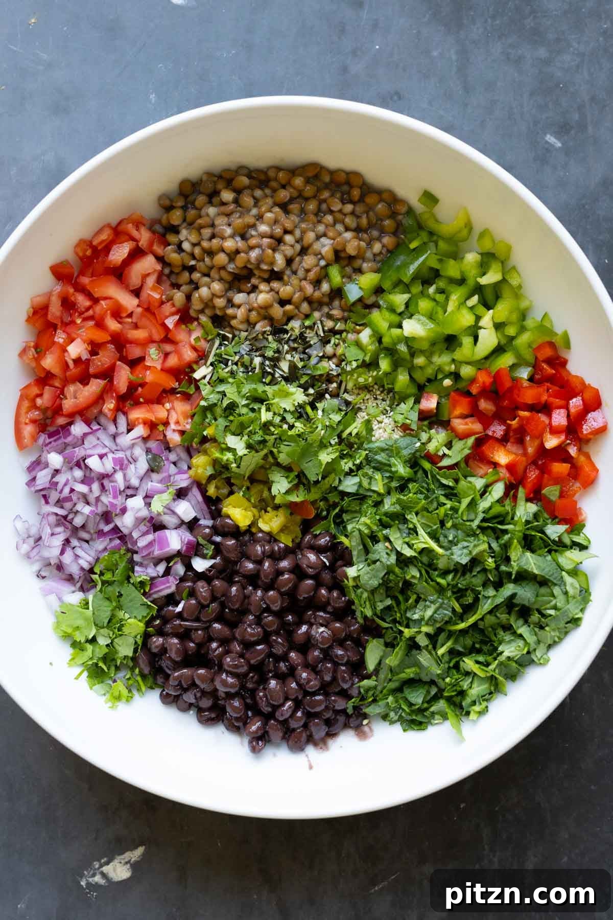 dense bean salad ingredients in the bowl before adding the dressing